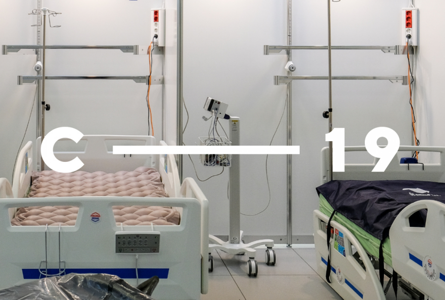 Fotogrāfija ar divām slimnīcas gultām virs kura ir teksts C-19